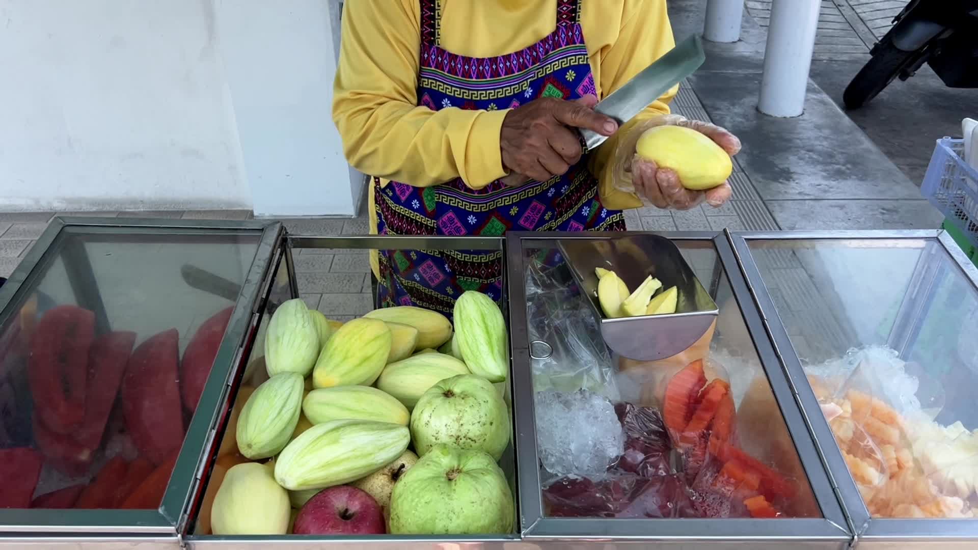 Street food fruit seller with a pushcart in Bangkok, Thailand